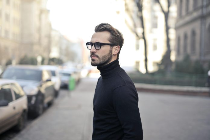 Vīrietis melnā maiciņā ar brillēm