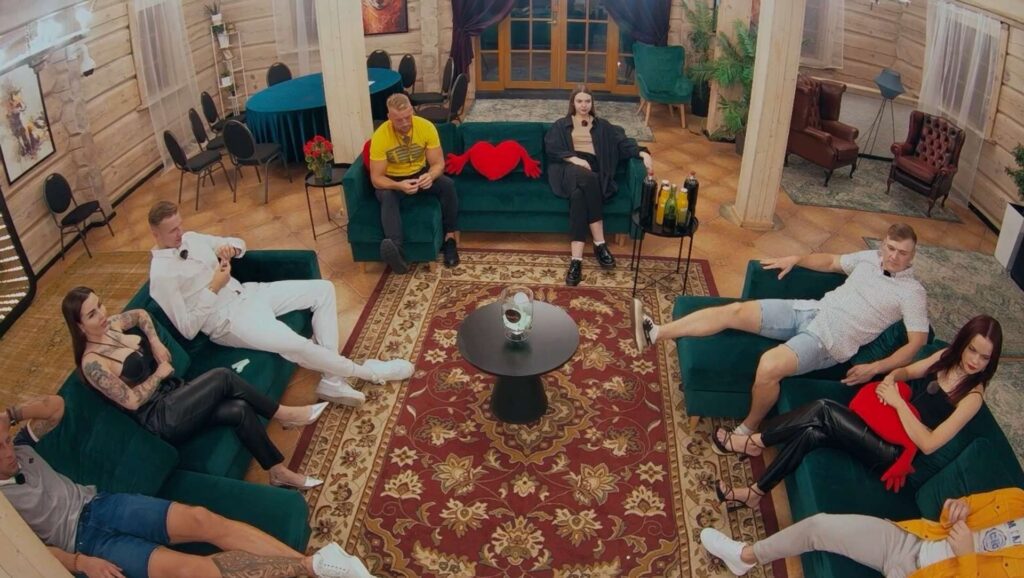 Visi dalībnieki sēž viesu istabā