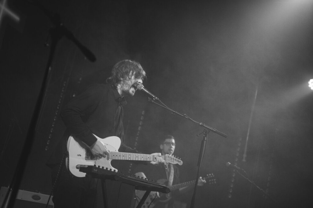 ''Detlef'', jeb Uldis Dirnēns uzstājas uz skatuves ar ģitāru.