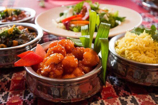 ''Himalaju Āzijas Virtuve'' ēdienkartes ēdieni uz galda.