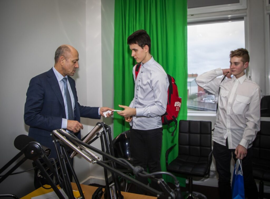 uzņēmējs jaunietim iedod vizītkarti