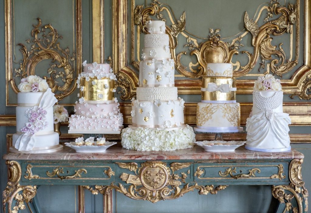 "Sweet Events" dažādas baltas kāzu kūkas pie greznas sienas