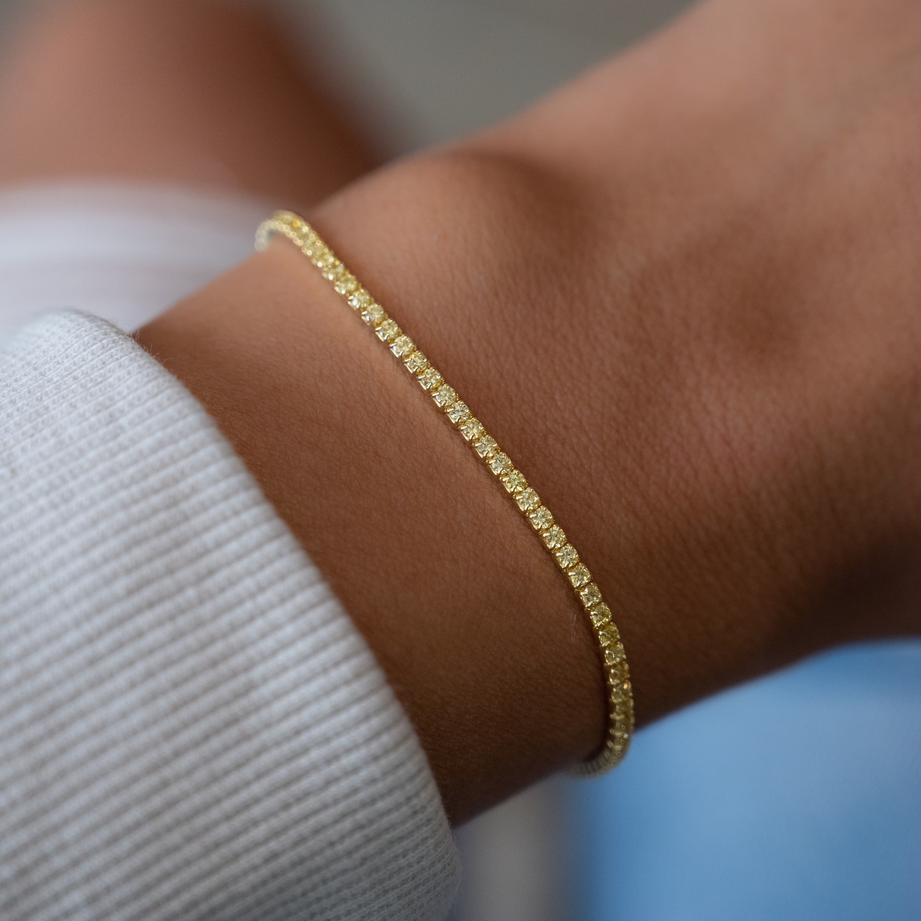 Zelta tenisa aproce ar dzelteniem dimantiem sievietei baltā kreklā