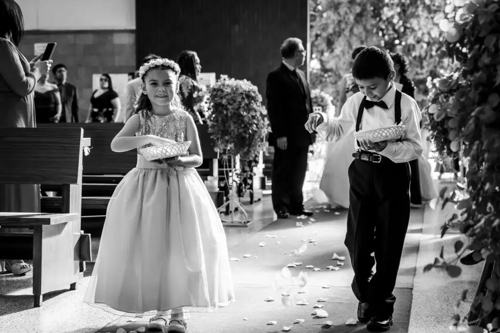 Bērni iesāk kāzu ceremoniju ejot pa celiņu baznīcā.
