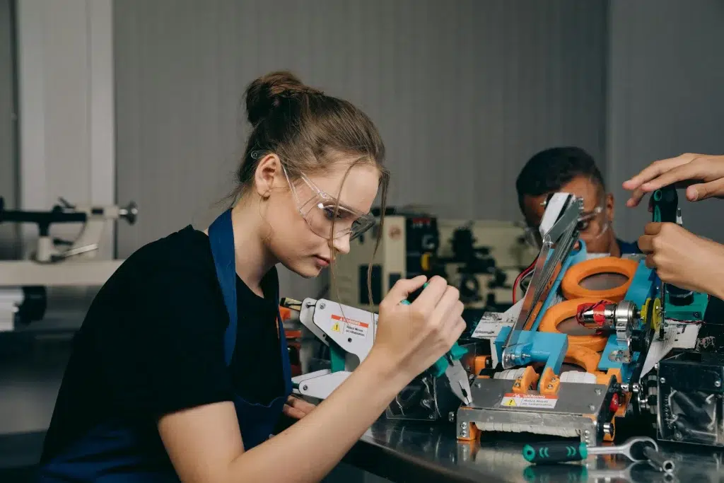 Meitene piedalās robotikas pulciņā.