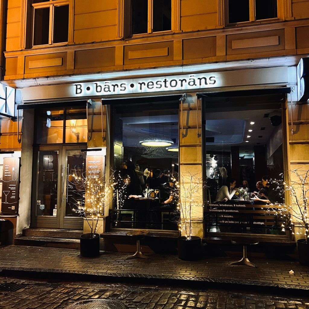 B Bārs Restorāns Rīgas centrā izgaismots vakarā.