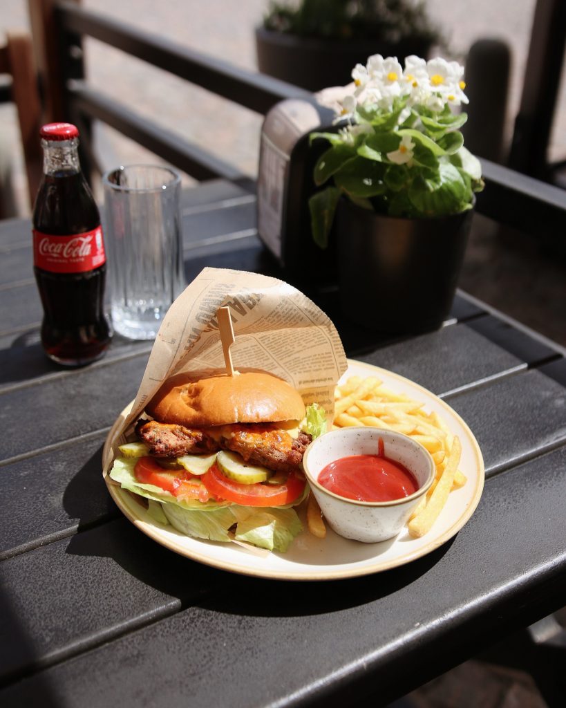 Restorāns "Kursas Zeme"  burgeris ar fri kartupeļiem un mērci.