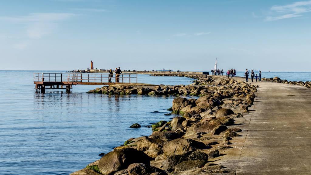Mangaļsalas mols ar ceļu un akmeņiem jūras krastā.