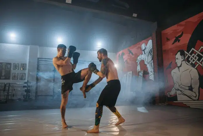 MMA Rigā. Divi vīrieši cīnās ar boksa cimdem rokās.