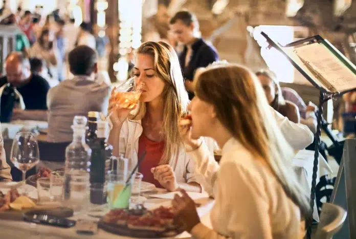 Kur doties vakariņās Rīgā? Divas sievietes ēd vakariņas pie galda.