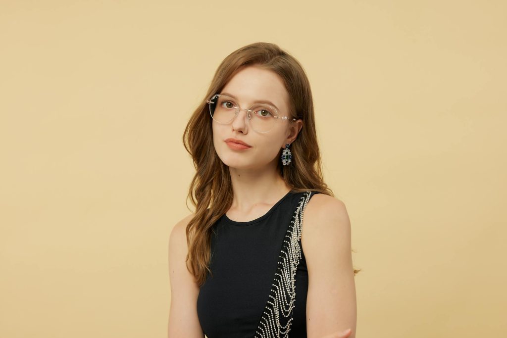 Sieviete ar apaļām brillēm un bez kosmētikas