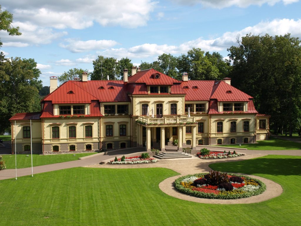 Dikļu pils ar gaiši dzeltenu fasādi un sarkanu jumtu