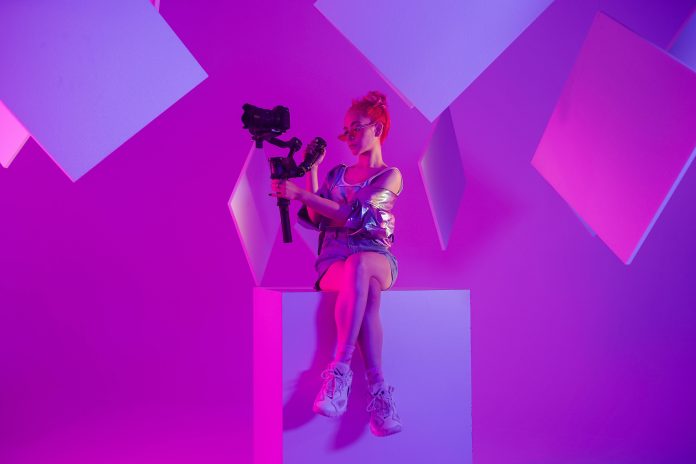 Modes influenceri. Sieviete sēž uz kastes ar fotokameru rokās