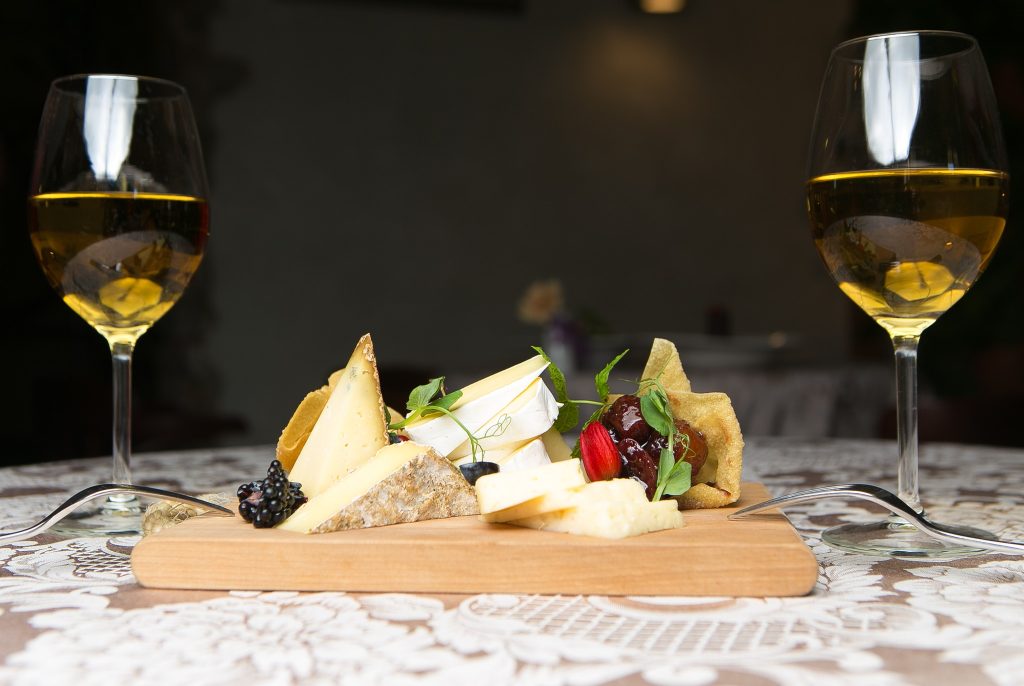 Spāņu uzkodu plate ar baltā vīna glāzēm