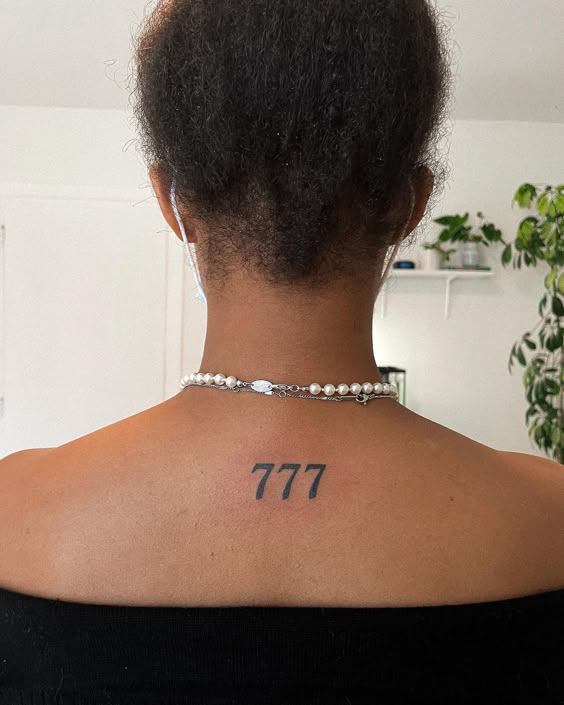 Sievietei uz muguras tetovējums ar skaitli 777