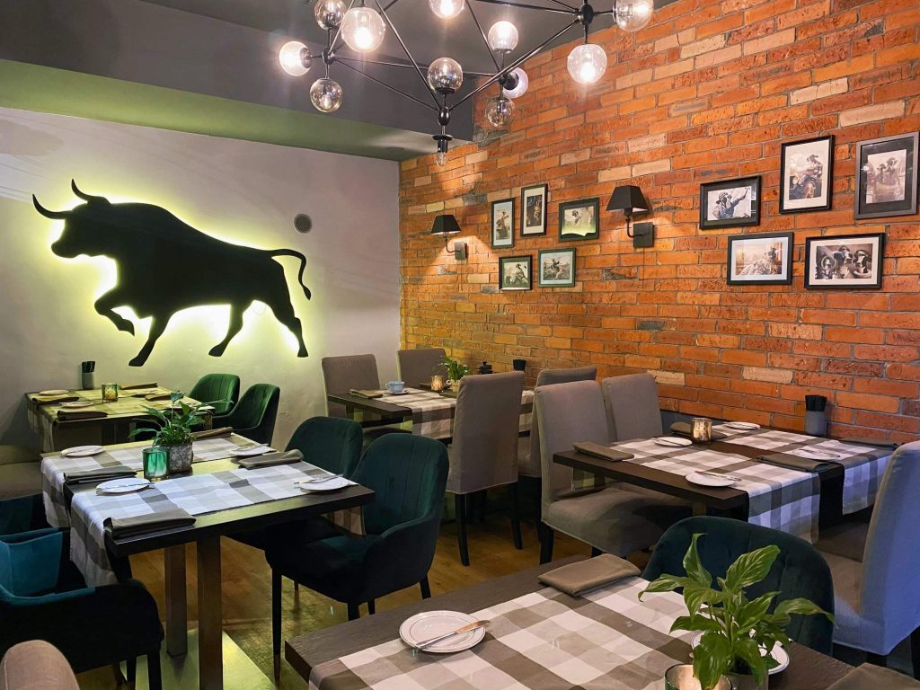"Beef Eater’s" restorāna interjers ar lielu bulli pie sienas
