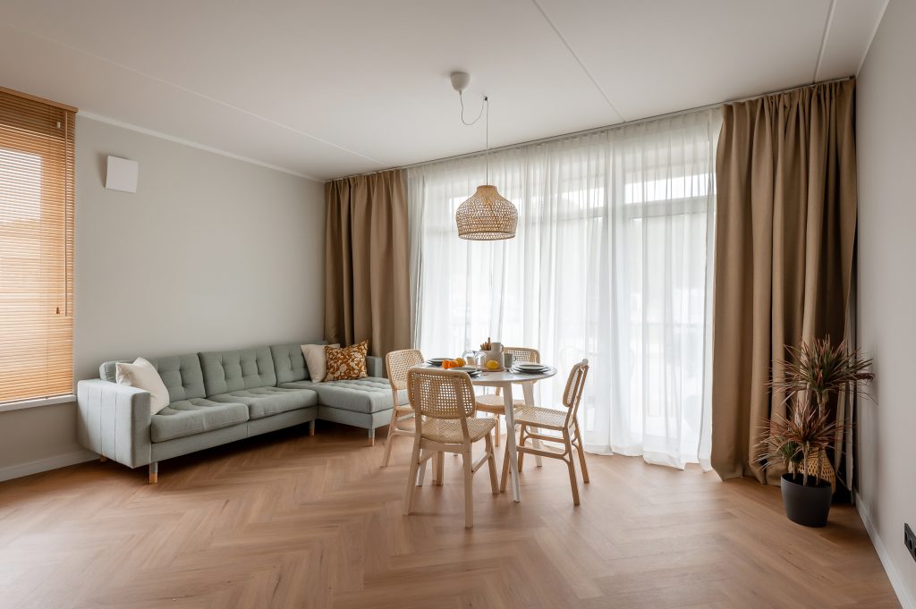 Gaiša viesistaba ar zaļu dīvānu