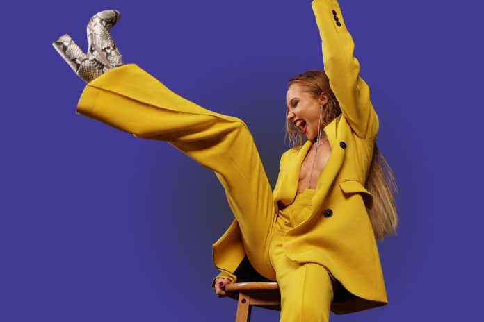 Modes tendences 2025. gadā. Sieviete dzeltenā kostīmā