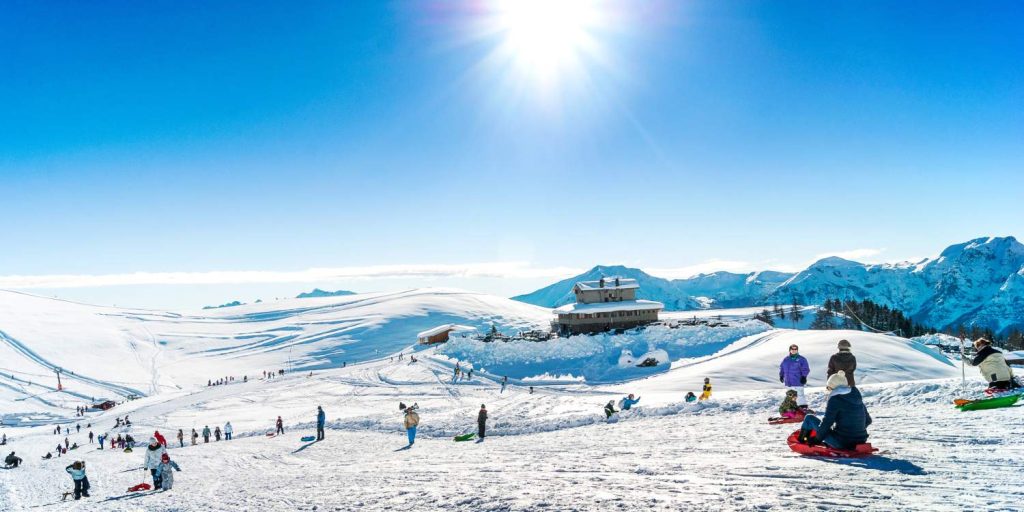 Cilvēki izklaidējas ziemā uz kalna Itālijā