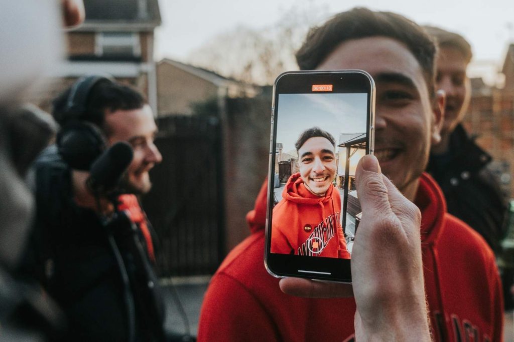 Vīrietis filmē video caur telefonu