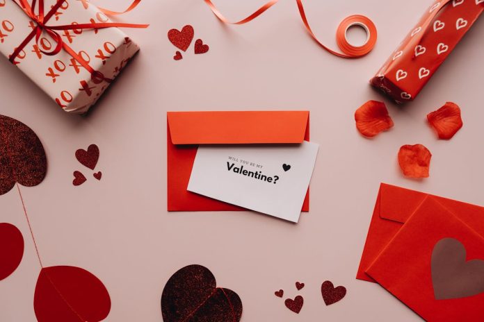 Valentīndienas kartiņa sarkanā aploksnē uz galda