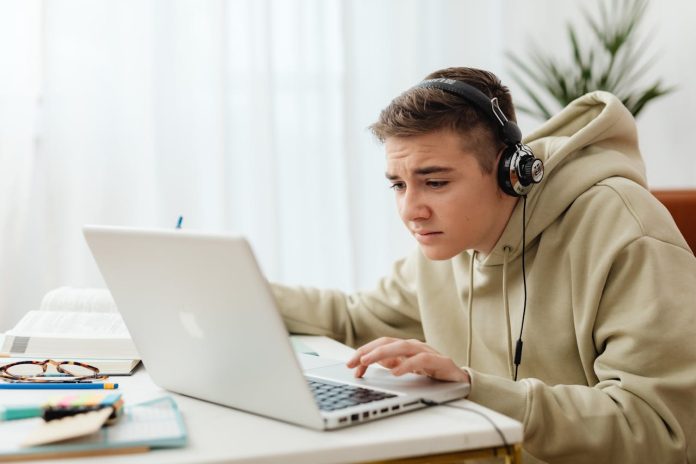 Jauns vīrietis skatās Apple datorā
