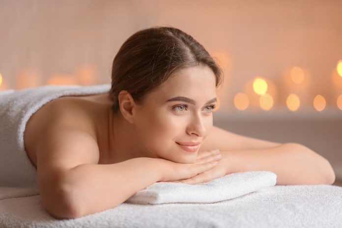 Jauna sieviete smaida un atpūšas SPA