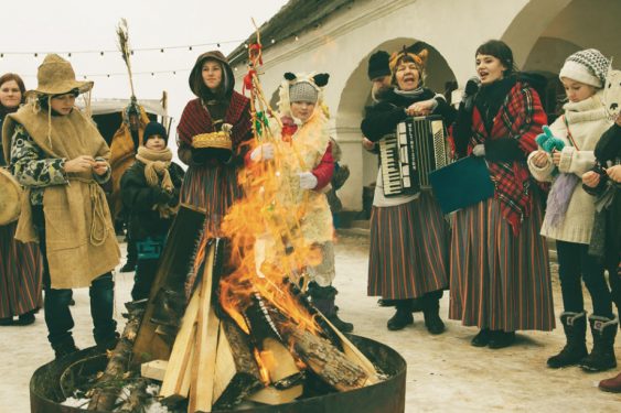 Meteņu dienas tradīcijas: cilvēki stāv apkārt ugunskuram