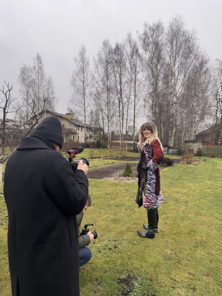 Rojs Rodžers stāv ārā mētelī