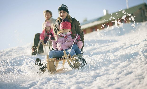 Sieviete ar bērnu brauc ar ragaviņām lejā pa kalnu