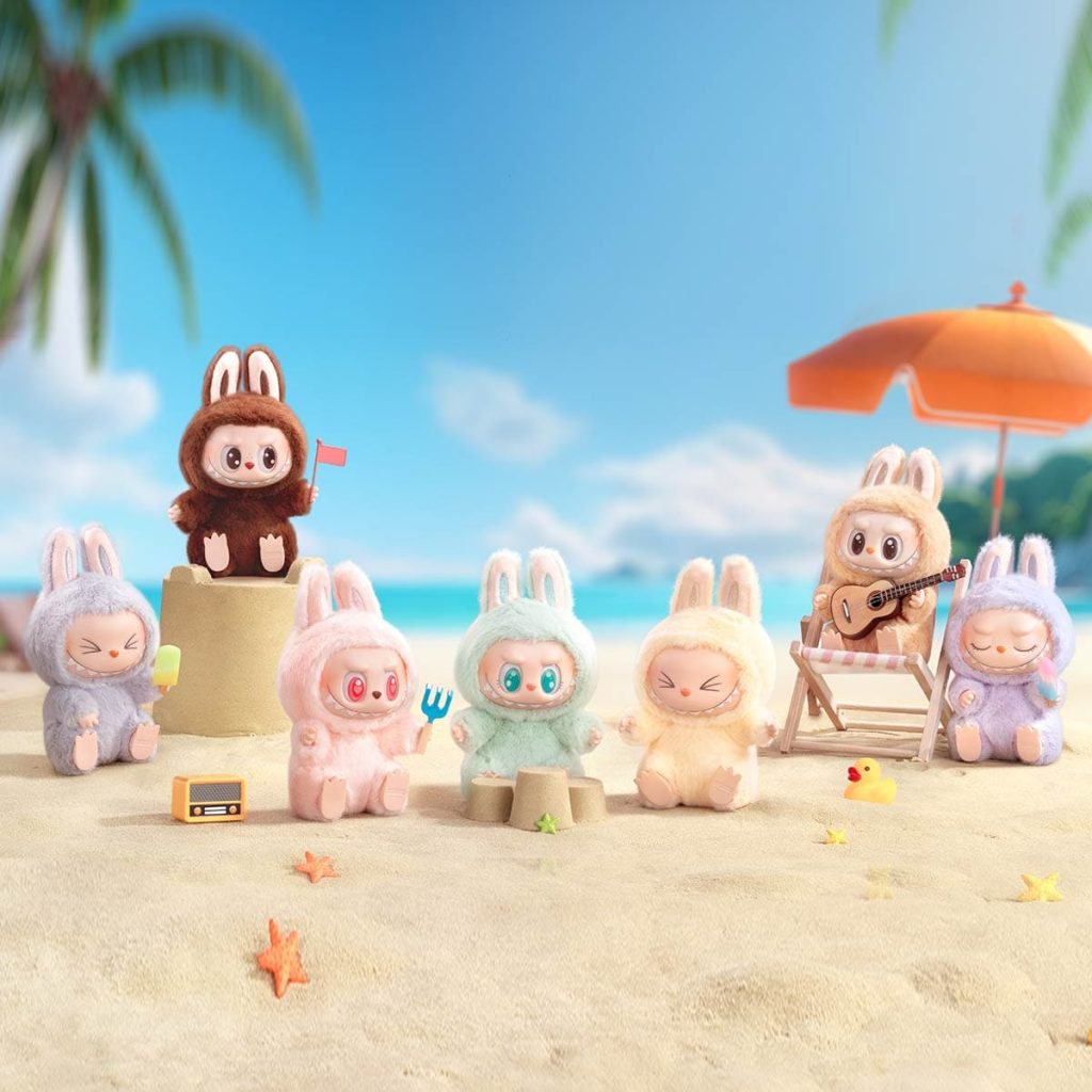 Vairākas labubu rotaļlietas novietotas pludmalē.