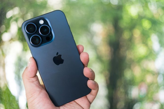 Cilvēks rokās tur tumši zilu iPhone