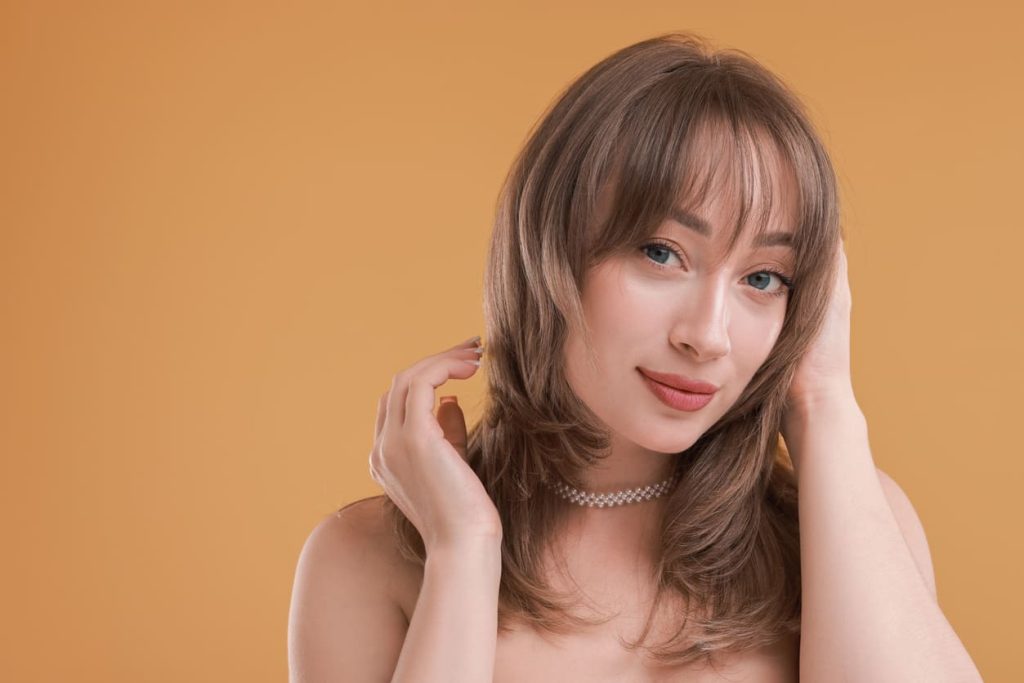 Sieviete ar matu griezumu, kurš izceļ sejas kontūru.