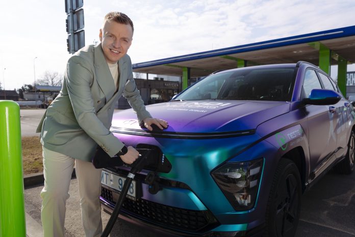 Vīrietis lādē elektroauto