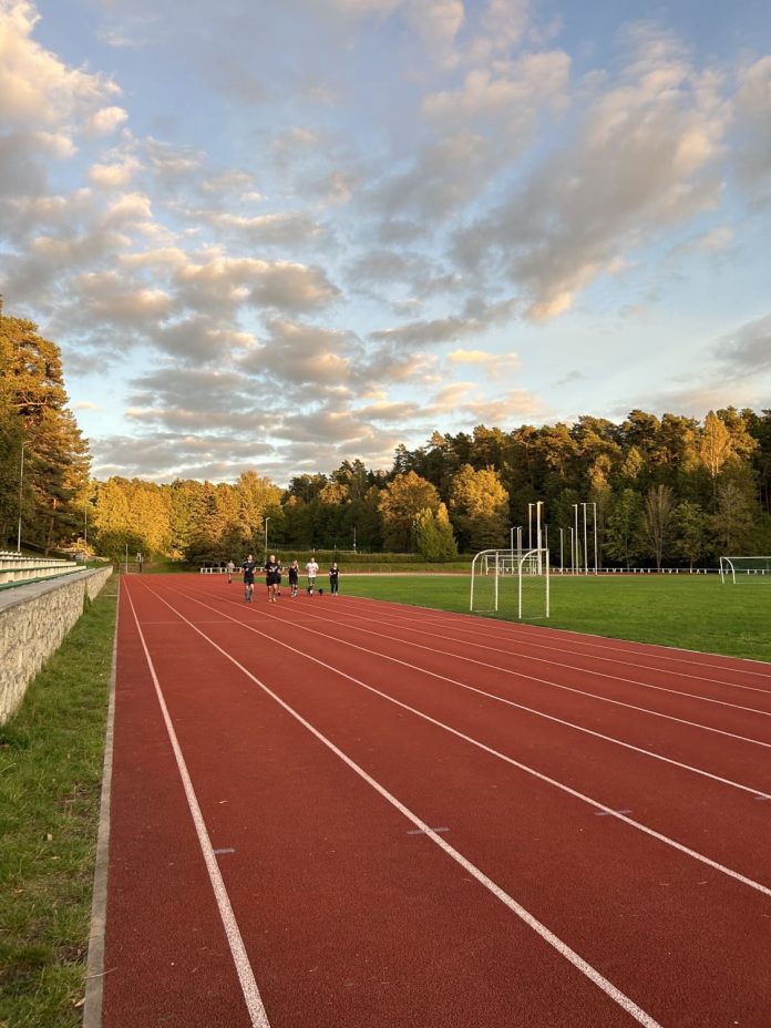 Cilvēki skrien pa stadionu